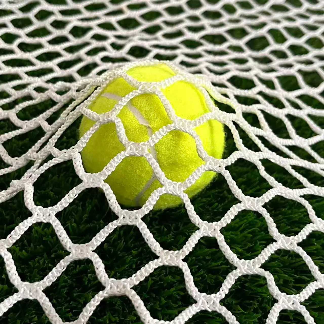 White practice cage netting, 20 mm mesh, 3 mm twine, with tennis ball on artificial turf